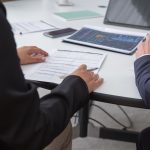 Profissionais analisam documentos em um ambiente de escritório.