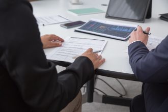 Profissionais analisam documentos em um ambiente de escritório.