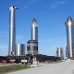 Protótipos da nave Starship posicionados na plataforma de lançamento da SpaceX, em Brownsville, Texas, sob céu claro.