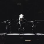 Drone profissional ao lado de seu estojo de armazenamento.
