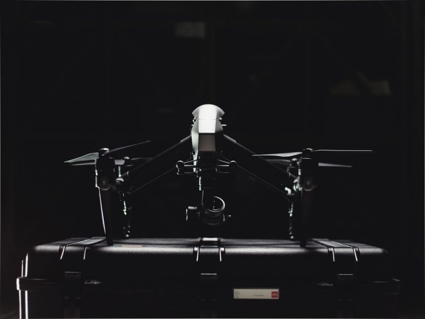 Drone profissional ao lado de seu estojo de armazenamento.