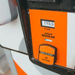Detalhe de uma bomba de gasolina exibindo preço e nível de octanagem 87.